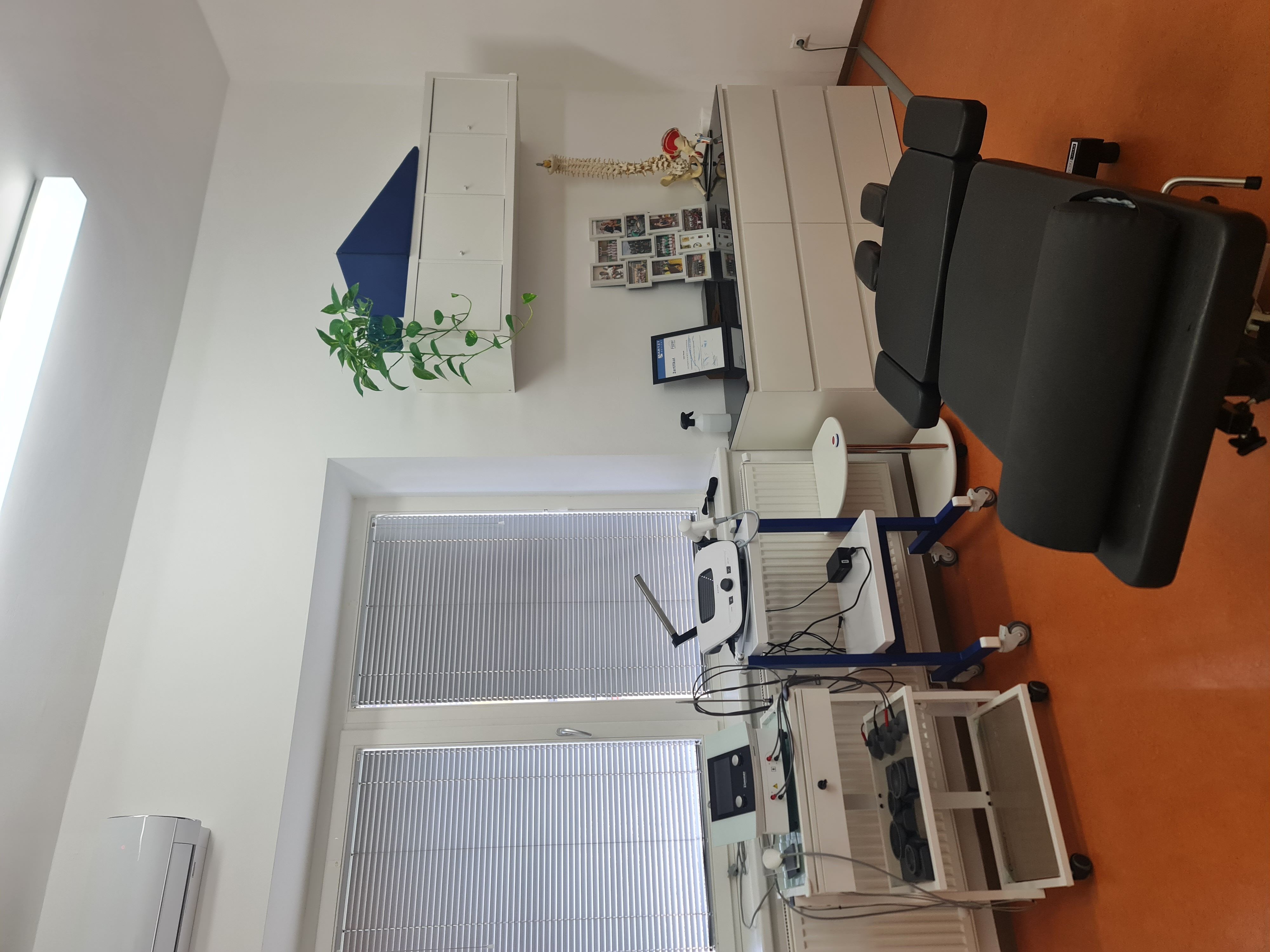 A medical examination room with an eye testing machine and a black patient chair.