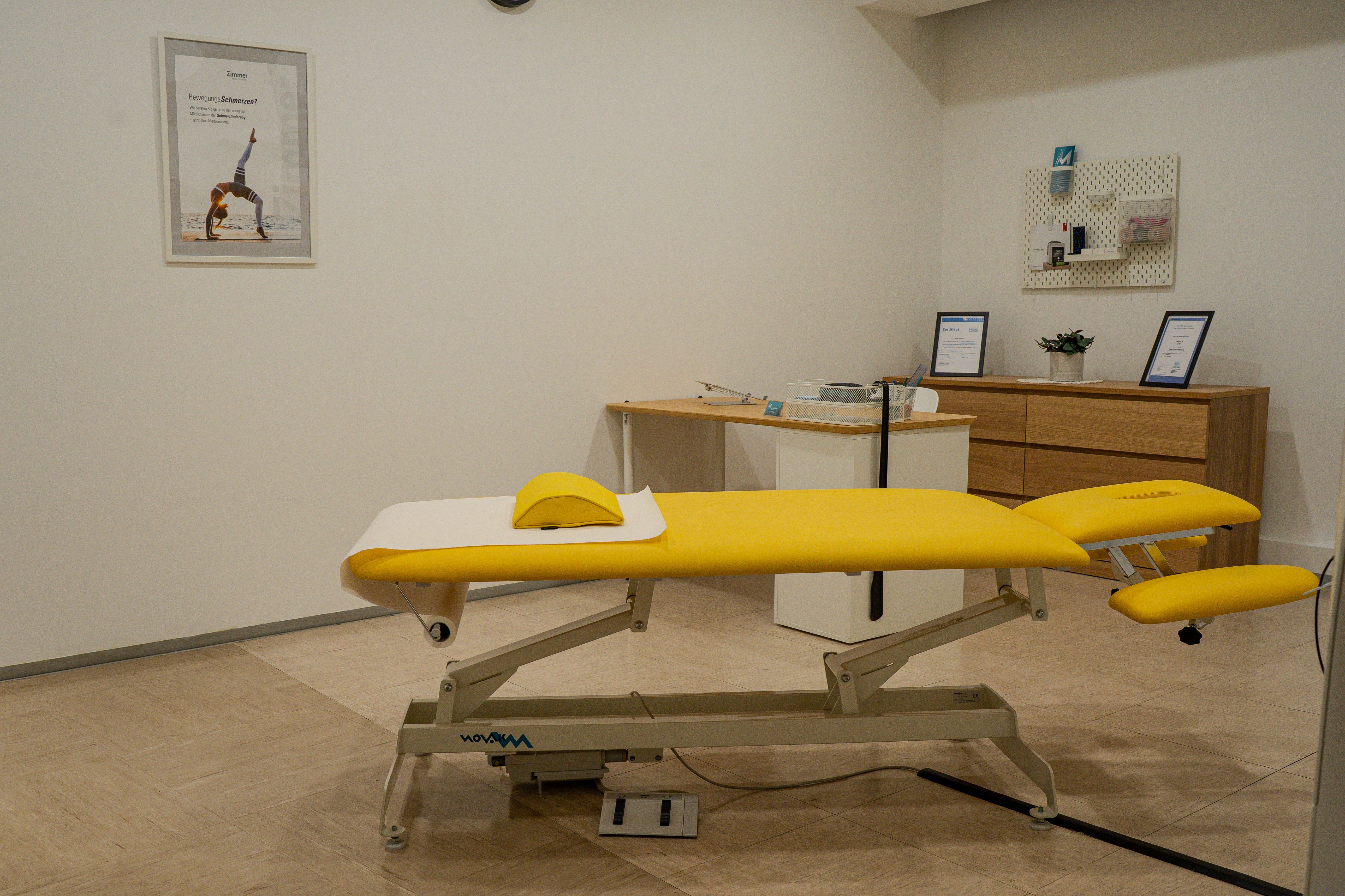Bright yellow examination table in a clean, modern physical therapy treatment room.